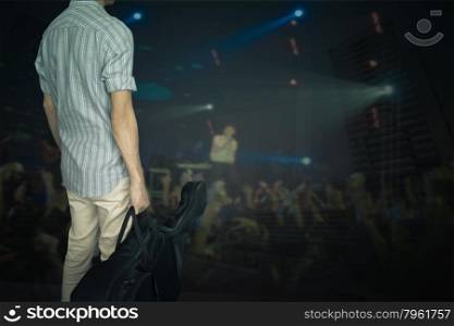 stylish young asian hipster man wear scott strip shirt, hold guitar bag, for concert travelling music concept