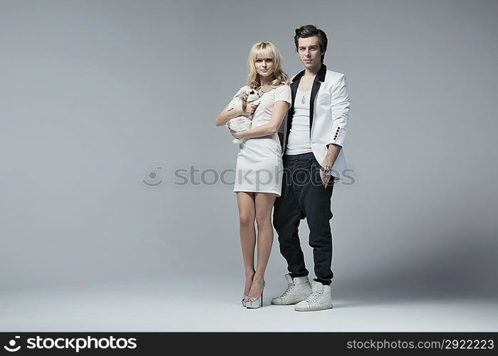 Stylish young couple posing with their cute rabbit