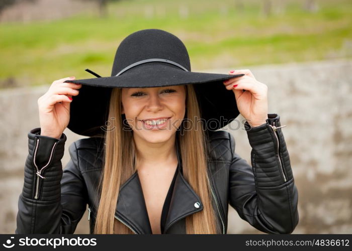 Stylish young woman with beautiful hat in the field