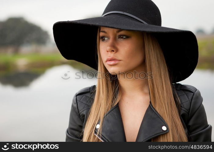 Stylish young woman with beautiful hat with a beautiful landscape of background