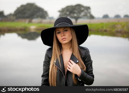 Stylish young woman with beautiful hat with a beautiful landscape of background