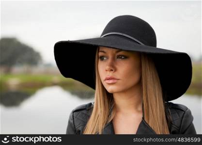 Stylish young woman with beautiful hat with a beautiful landscape of background