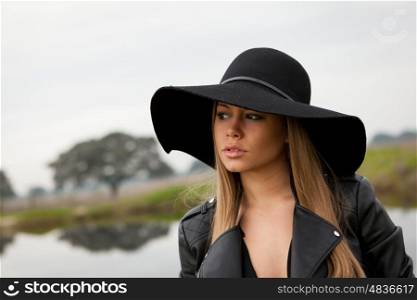 Stylish young woman with beautiful hat with a beautiful landscape of background
