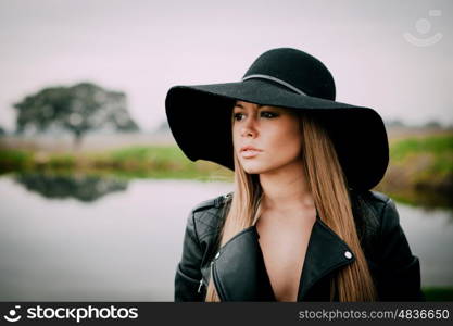 Stylish young woman with beautiful hat with a beautiful landscape of background