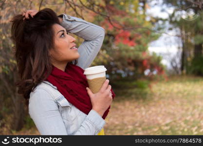 Stylish young woman with coffee outdoors during fall