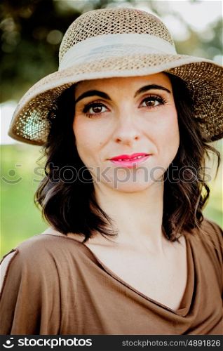 Stylish young woman with straw hat in the field
