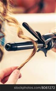 Stylist curling hair for young woman.. Stylist curling hair for young woman. Girl care about her hairstyle