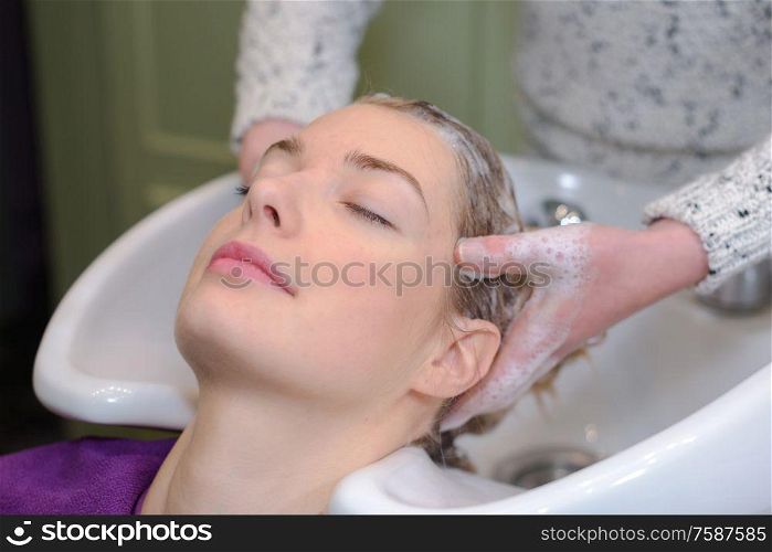 stylist is washing hair of a client