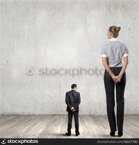 Subordination concept. Miniature of young businessman and bossy businesswoman
