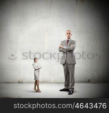 Subordination concept. Miniature of young businesswoman and bossy businessman