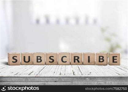Subscribe word on a wooden sign on a table in a bright room