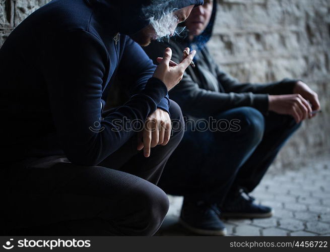 substance abuse, addiction, people and bad habits concept - close up of young men smoking cigarettes outdoors