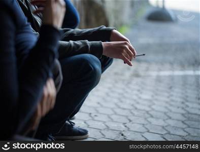 substance abuse, addiction, people and bad habits concept - close up of young men smoking cigarettes outdoors