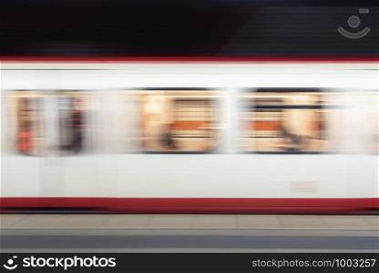 Subway train in motion in an underground station. Blur background of means of public transport. German high-speed subway train in motion.