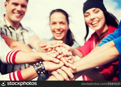success and gesture concept - close up of teenagers hands on top of each other outdoors