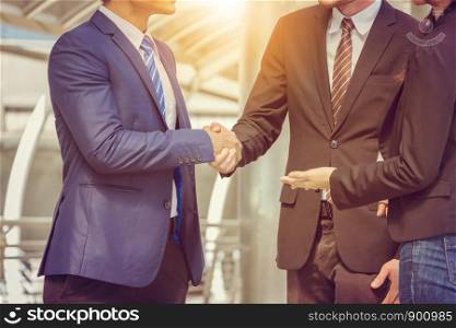Success and Happiness Team Concept, Close up of Business man handshake with businesswomen standing next to them over blurred city background
