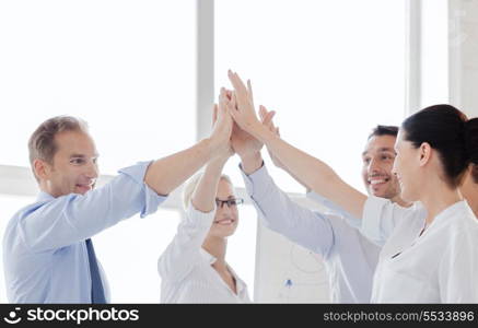 success and winning concept - happy business team giving high five in office