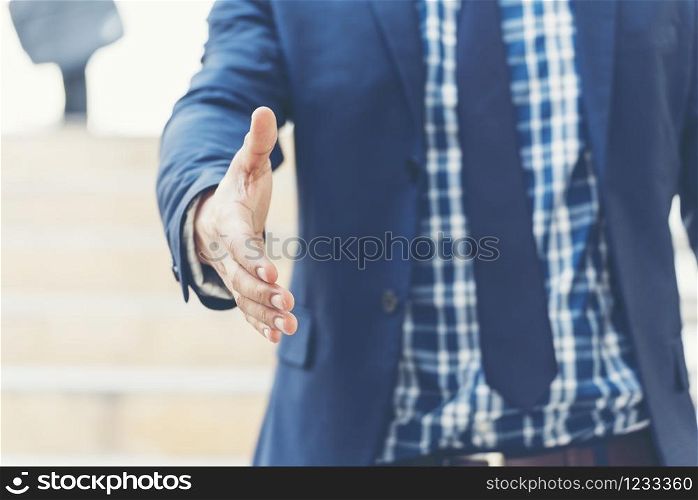 Success Business man giving hand shake. Team Business Partners shaking hands together to Greeting Start up new project. Corporate Teamwork Partnership outside office modern city as background. Businessman with Hands together.