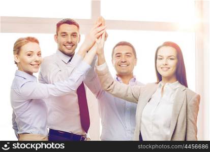 success, business, office and winning concept - happy business team giving high five in office
