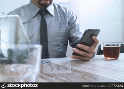 success businessman hand using smart phone,digital tablet docking smart keyboard,coffee cup on wooden desk