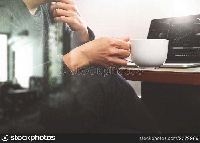 success businessman hand using smart phone,digital tablet docking smart keyboard,coffee cup on wooden desk,filter effect