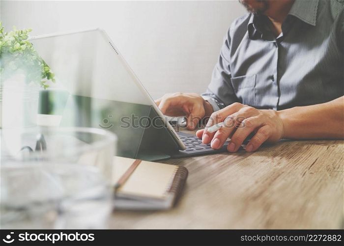 success businessman hand using stylus pen,digital tablet docking smart keyboard on wooden desk,filter film effect