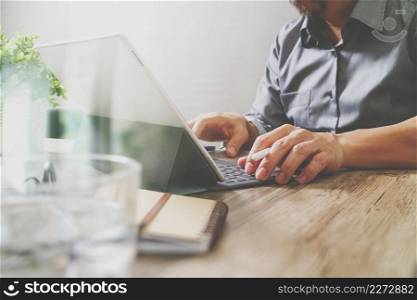 success businessman hand using stylus pen,digital tablet docking smart keyboard on wooden desk,filter film effect