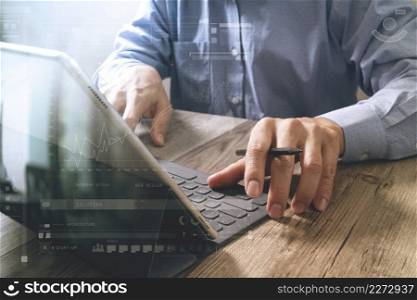 success businessman hand using stylus pen,digital tablet docking smart keyboard on wooden desk,icons graphic screen effect