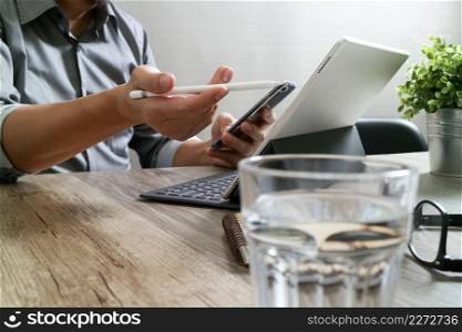 success businessman hand using stylus pen,digital tablet docking smart keyboard on wooden desk