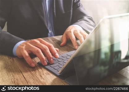 success businessman hand working with digital tablet docking smart keyboard on wooden desk,filter effect