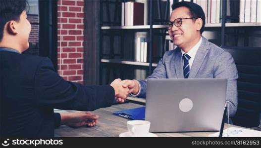 Success collaboration partners sign contract and shake hands after success business joint venture deal. Diversity Businessman shake hands together in a meeting. Trustworthy meeting business concept.