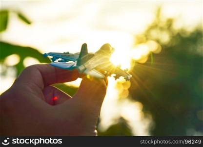 Success concept Airport, Holding toy Airplane in the sky at sunset. Flying to the sky