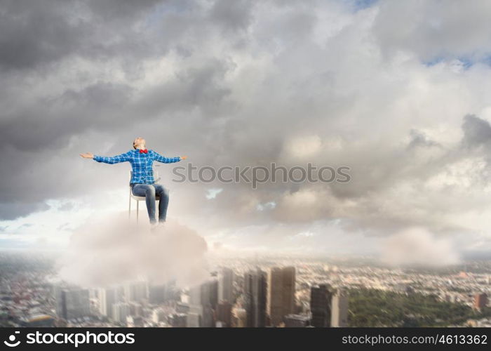 Success concept. Young girl sitting in chair high in sky