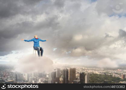 Success concept. Young girl sitting in chair high in sky