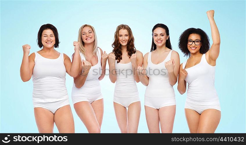 success, friendship, beauty, body positive and people concept - group of happy plus size women in white underwear celebrating victory over blue background