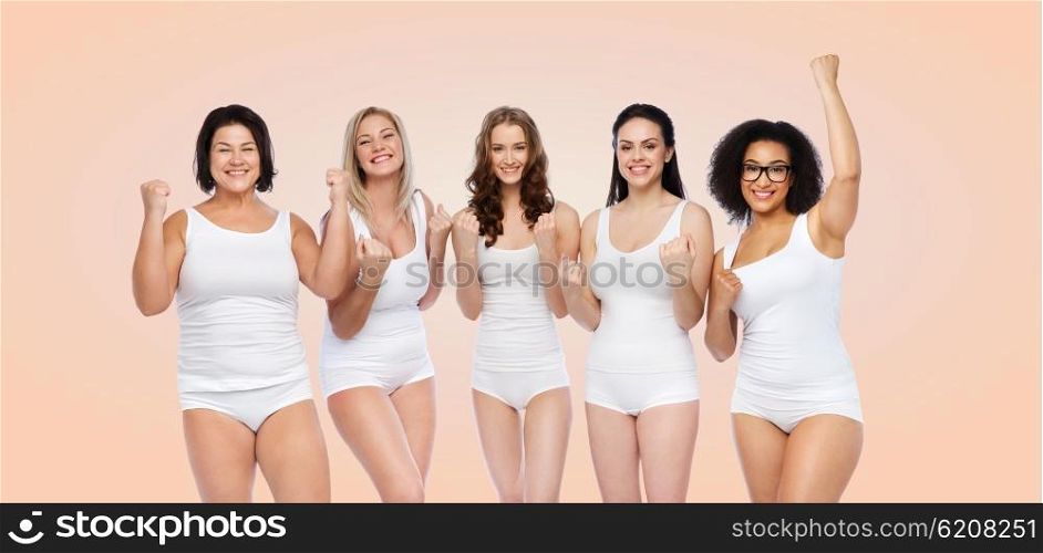 success, friendship, beauty, body positive and people concept - group of happy plus size women in white underwear celebrating victory over beige background