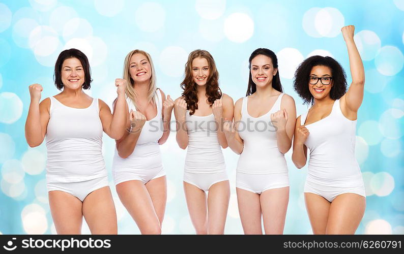 success, friendship, beauty, body positive and people concept - group of happy plus size women in white underwear celebrating victory over blue holidays lights background