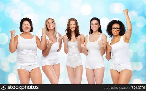 success, friendship, beauty, body positive and people concept - group of happy plus size women in white underwear celebrating victory over blue holidays lights background