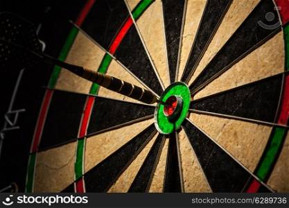 Success hitting target aim goal achievement concept background - dart in bull&#39;s eye close up
