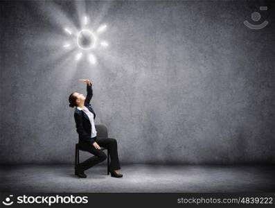 Success in business. Image of businesswoman sitting on chair under sun lights