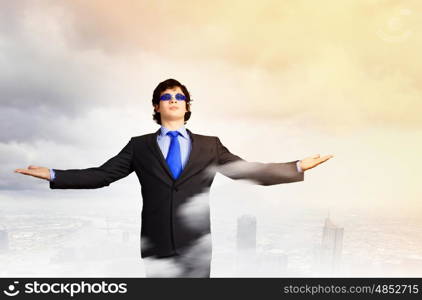 Success in business. Image of powerful businessman standing against urban scenics