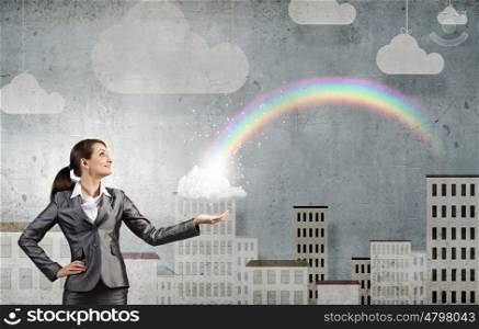 Success in business. Young businesswoman and colorful rainbow in hand