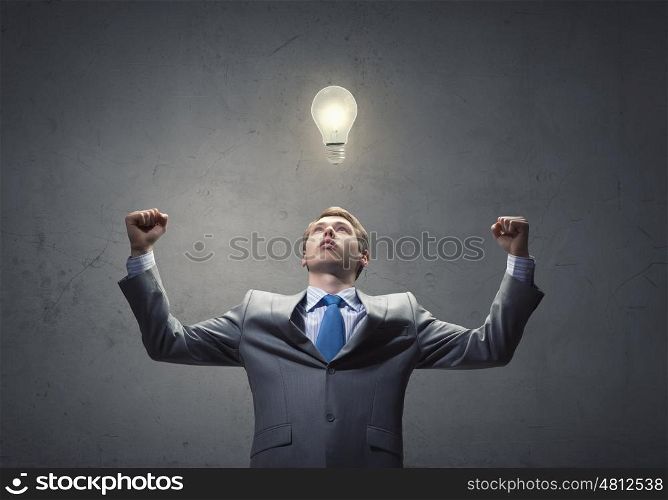 Success in business. Young handsome businessman with hands up celebrating success
