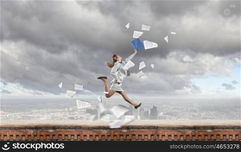 Success in business. Young happy businesswoman with folder in hand jumping cheerfully