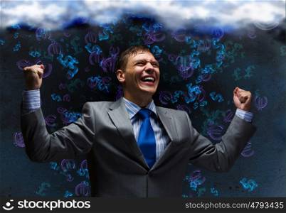 Success in business. Young joyful businessman with hands up celebrating success
