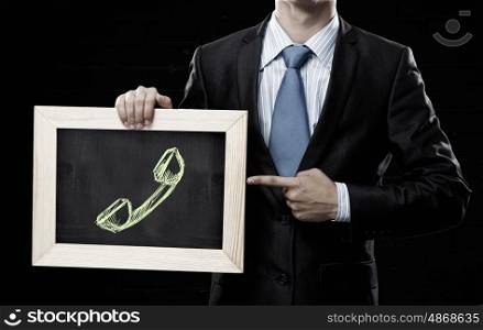 Success of sales. Unrecognizable businessman holding chalkboard with calls concept