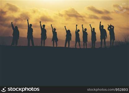 Success of teamwork collaboration and freedom on silhouette sunset background. business concept