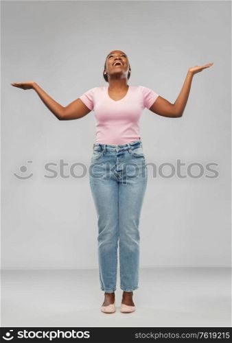 success, winning gesture and people concept - happy young african american woman celebrating victory over grey background. happy african american woman celebrating success
