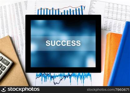 success word on tablet with financial graph background
