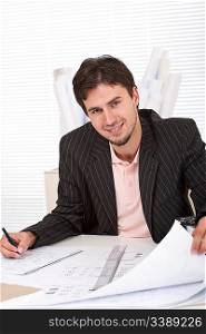 Successful architect man working with plans at office